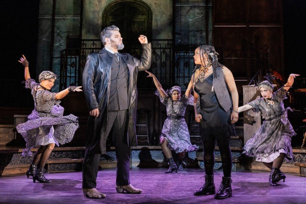 Theatrical performance with actors in dramatic poses, vibrant costumes on stage, capturing a moment of intense expression.