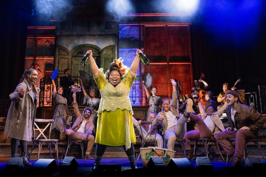Lively theater cast celebrating on stage with music and dance, vibrant costumes, and joyful expressions.