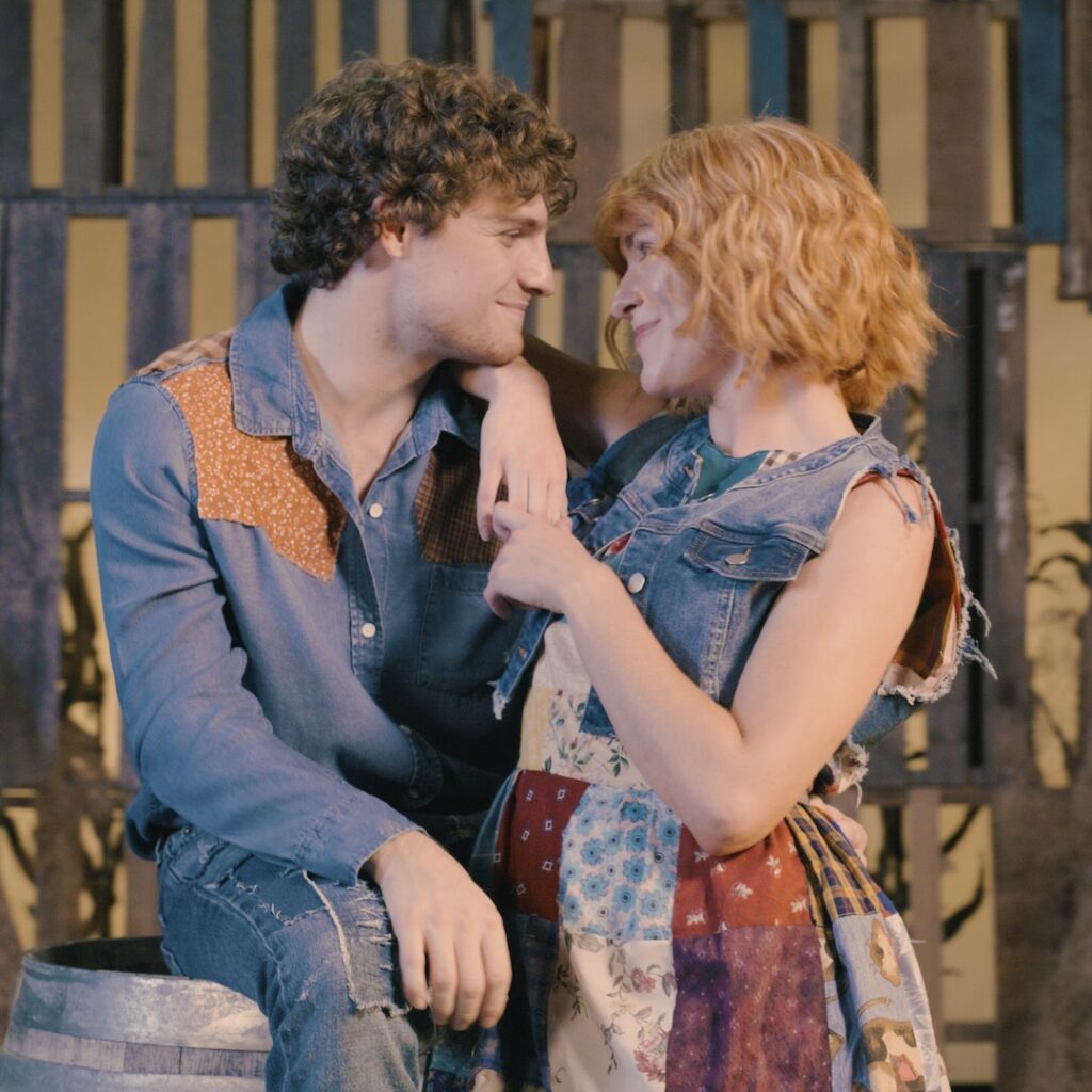 A couple gazes lovingly, dressed in patchwork denim, capturing a rustic and romantic moment together.